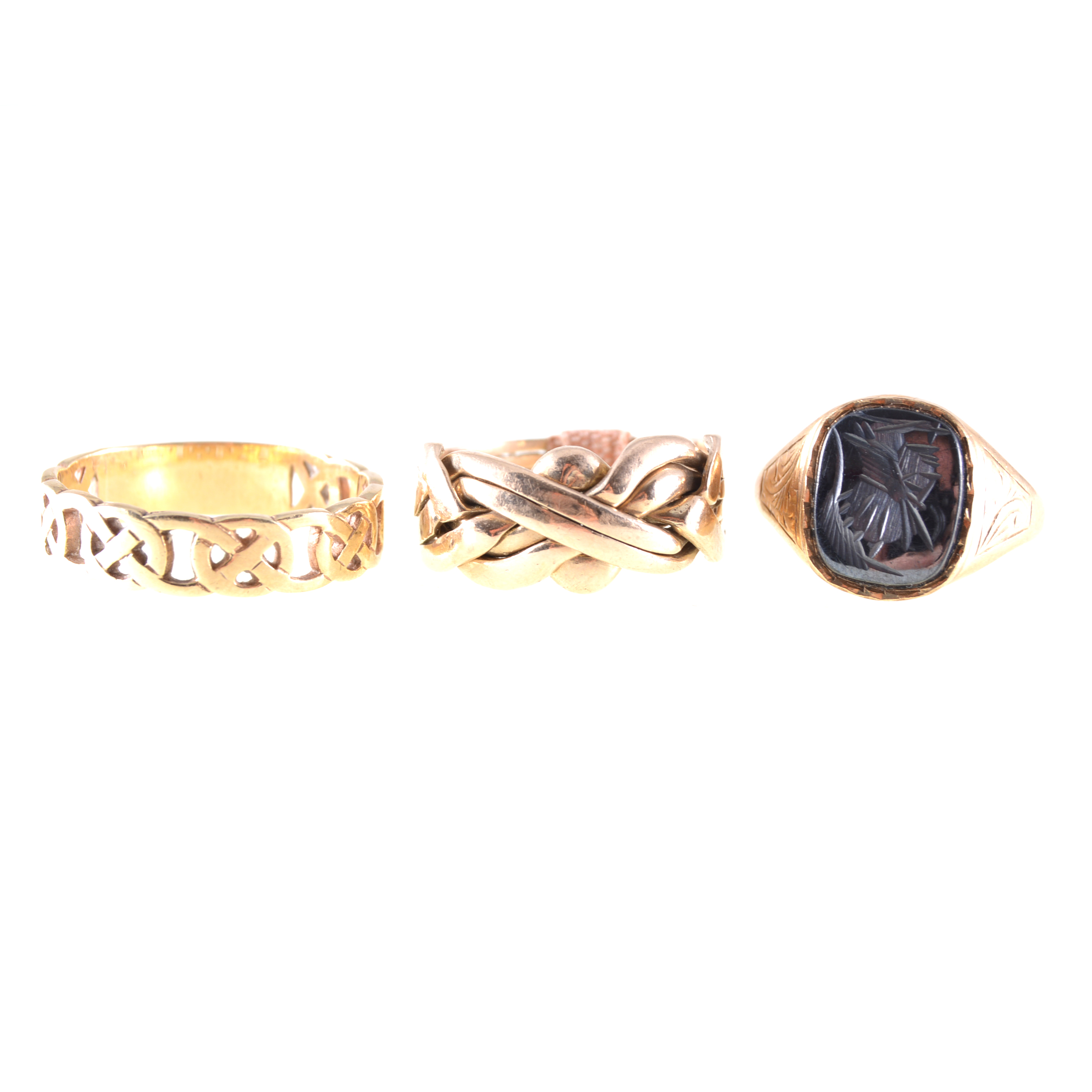 Three gold rings, a 9 carat yellow gold signet ring with intaglio carved haematite warriors head,