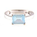 A modern blue topaz dress ring, the rectangular step cut stone 7.8mm x 5.