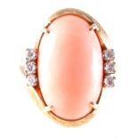 A coral and diamond dress ring, an oval cabochon cut coral 20mm x 13mm,