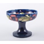 William Moorcroft 'Pansy' footed bowl, flowers on a navy ground circa 1920, diameter 16cm,