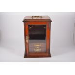 A mahogany smokers cabinet, glazed door revealing two drawers 38cm high, a twin handled copper pan,