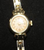 A lady's 14ct gold wrist watch, on a gilt metal bracelet.