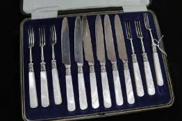 A cased set of six pairs of mother of pearl handled dessert eaters with silver collars.