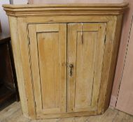 A late 18th century pine hanging corner cupboard, W.64cm