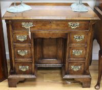 A George II style featherbanded walnut kneehole desk, W.86cm