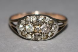 An early 20th century gold and diamond cluster dress ring, size Q.