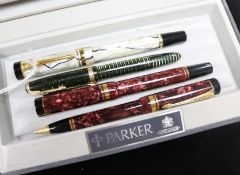 A Parker Duofold Black and Pearl fountain pen, a similar Red Marble pen and ballpoint set and a