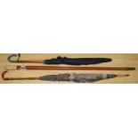 An ivory handled walking stick and 2 umbrellas