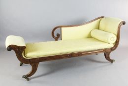 A Regency mahogany chaise longue, with anthemion carved show-wood frame and sabre legs, on lions paw