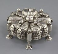 A continental unmarked silver trinket box, of shaped circular form, with central boss unscrewing