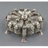 A continental unmarked silver trinket box, of shaped circular form, with central boss unscrewing