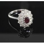 A 18ct white gold ruby and diamond oval cluster ring, size O.