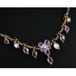 A late Victorian gold, seed pearl and amethyst drop necklace, with central foliate motif and set