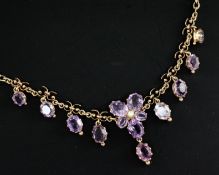 A late Victorian gold, seed pearl and amethyst drop necklace, with central foliate motif and set