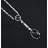 A white gold, cabochon sapphire and diamond set drop pendant necklace, the two sapphire with a total