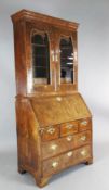 An early 18th century walnut bureau bookcase, with two glazed doors enclosing pigeonholes and