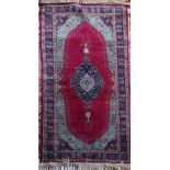 A Sparta style red and green ground rug, with central medallion and three row border, 5ft 8in by 3ft