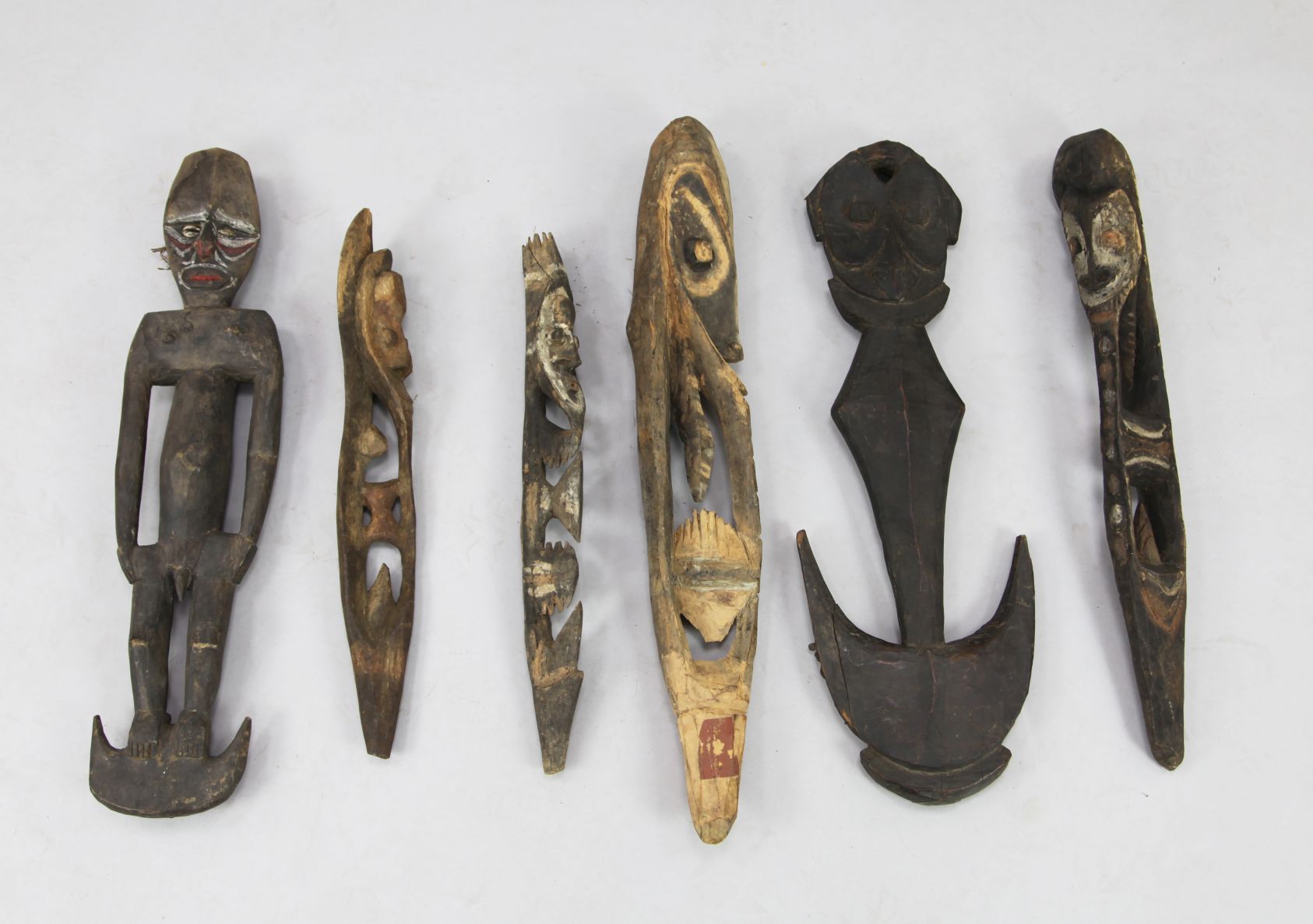 Papua New Guinea Sepik river carvings; the bench incised with masks and stylised figures, with