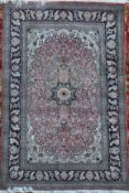 A Chinese silk pink ground rug, with field of scrolling foliage, central medallion and multi row