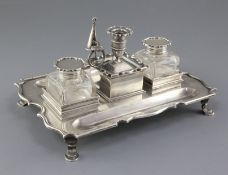 An Edwardian silver inkstand by C.S. Harris & Sons Ltd, of shaped rectangular form, with two mounted