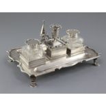 An Edwardian silver inkstand by C.S. Harris & Sons Ltd, of shaped rectangular form, with two mounted