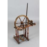 An early 19th century mahogany, oak and fruitwood spinning wheel, with bone and ivory decoration,
