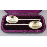 A cased pair of Victorian silver apostle spoons, with hexagonal stems and gilded bowls, Edward