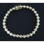 An 18ct gold & diamond line bracelet, set with thirty one collet set round cut stones, 7in.