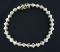 An 18ct gold & diamond line bracelet, set with thirty one collet set round cut stones, 7in.