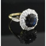 An 18ct gold, sapphire and diamond oval cluster ring, with diamond set shoulders, size O.