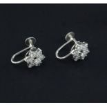 A pair of 9ct white gold and diamond cluster earrings, of flowerhead design, each set with seven