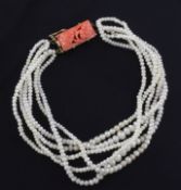 A multi strand natural pearl bracelet with carved coral set gold clasp, with accompanying GCS Full