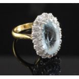 An 18ct gold aquamarine and diamond oval cluster ring, size M.