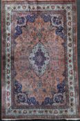 A Persian silk rug, with central foliate medallion in a field of scrolling foliage, on a pink