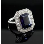 A 1920's/1930's platinum, synthetic sapphire and diamond cluster dress ring, the central emerald cut