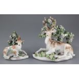 Two Derby porcelain models of recumbent stags, c.1765, each seated before bocage with applied