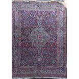 A Kashan red ground carpet, with central foliate medallion in a field of scrolling foliage, with
