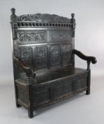 A 17th century style inlaid oak monks bench, carved with armorials and inscribed 'de bon vouloir