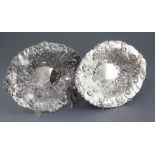 A matched pair of late Victorian silver oval dishes, embossed with scrolls and foliate decoration,