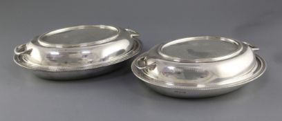 A pair of George V silver entree dishes and covers by Viner's Ltd, of oval form, with gadrooned