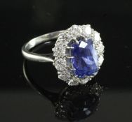 A platinum, sapphire and diamond oval cluster ring, the rectangular cushion cut sapphire of good