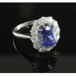 A platinum, sapphire and diamond oval cluster ring, the rectangular cushion cut sapphire of good