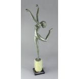 A green patinated bronze figure of a nude dancer in the style of Josef Lorenzl, signed on the