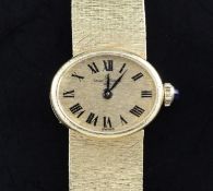 A lady's 1970's 18ct gold Baume & Mercier manual wind wrist watch, with oval Roman dial, on textured