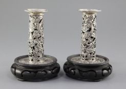 A pair of early 20th century Chinese Export repousse silver dwarf candlesticks, pierced and
