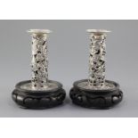 A pair of early 20th century Chinese Export repousse silver dwarf candlesticks, pierced and