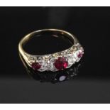 An early 20th century gold, ruby and diamond graduated five stone half hoop ring, size Q.