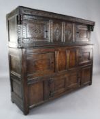 A late 17th century oak court cupboard, with carved frieze dated 1680, and two side doors over an