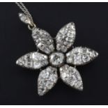 A Victorian gold, silver and diamond encrusted flower head pendant, set with old mine cut stones, on