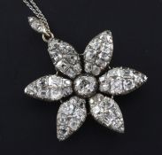 A Victorian gold, silver and diamond encrusted flower head pendant, set with old mine cut stones, on